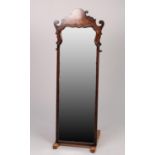 GEORGE I STYLE FIGURED WALNUT ROBING MIRROR, the oblong, bevel edged plate with shaped top, housed