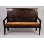 LATE EIGHTEENTH CENTURY CARVED OAK SETTLE, of typical form, the four panelled back well carved