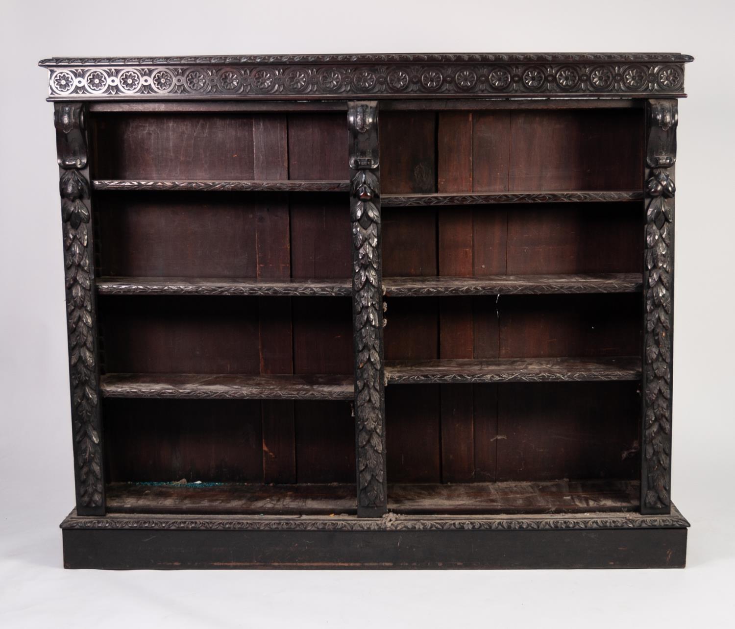 LATE NINETEENTH CENTURY CARVED DARK OAK OPEN BOOKCASE, the moulded top above a frieze carved with