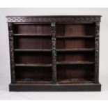 LATE NINETEENTH CENTURY CARVED DARK OAK OPEN BOOKCASE, the moulded top above a frieze carved with