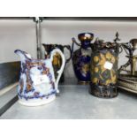 GRADUATED PAIR 'JACKFIELD' BLACK AND GILT POTTERY JUGS, EMBOSSED AND COPPER LUSTRE DECORATED LATE