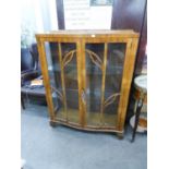 A 1950's FIGURED WALNUTWOOD SMALL DISPLAY CVABINET WITH BOW FRONT, ENCLOSED BY TWO ASTRAGAL GLAZED