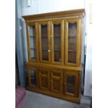 A LARGE WALNUT CHINA CABINET, WITH FOUR GLAZED DOORS ON AN ADVANCED BASE WITH TWO GLAZED DOORS AND A