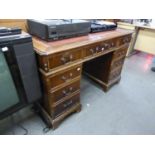 REPRODUCTION MAHOGANY KNEEHOLE DESK, HAVING RED LEATHER INSET TOP OVER THREE DRAWERS, EACH