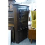 CARVED OAK DOUBLE CORNER CUPBOARD WITH GLAZED DOOR OVER A PANEL DOOR AND A SMALL OAK HALL