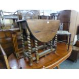 AN OAK DROP LEAF DINNG TABLE ON SPIRAL COLUMN LEGS