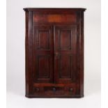 LATE GEORGIAN OAK AND MAHOGANY CROSSBANDED FLAT FRONTED CORNER CUPBOARD, the deep frieze above a