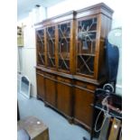 A REPRODUCTION YEW-WOOD VENEERED BREAKFRONT BOOKCASE, THE ASTRAGAL GLAZED UPPER PORTION BENEATH A