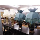 A PAIR OF CERAMIC ELECTRIC TABLE LAMPS WITH SHADES, GILT DECORATED WITH RING HANDLES AND ANOTHER