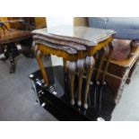 A NEST OF THREE MAHOGANY SHAPED OBLONG COFFEE TABLES, WITH CARVED BORDERS AND CABRIOLE SUPPORTS