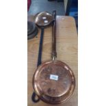 A BRASS CHESTNUT ROASTER, WITH BLACK METAL LONG HANDLE AND A MODERN COPPER BED WARMING PAN WITH LONG
