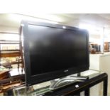A 37" TOSHIBA FLATSCREEN TV ON A MODERN STAND WITH GLASS SLIDING DOORS, A DVD PLAYER AND VIDEO