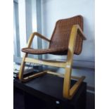 A MODERN LIGHT WOOD CANTILEVER BENTWOOD EASY ARMCHAIR WITH WOVEN WICKER BACK AND SEAT