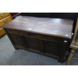 AN OAK ANTIQUE THREE PANEL FRONT COFFER WITH CARVING, HINGED TOP