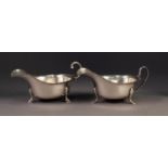 TWO GEORGIAN STYLE SILVER SAUCE BOATS with cyma borders, one with flying scroll handle ad stepped