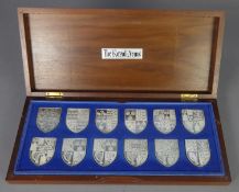 THE DANBURY MINT SET OF TWELVER SILVER SHIELD SHAPED INGOTS depicting 'The Royal Arms' as borne by