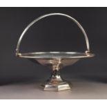 GEORGE V SILVER SWING HANDLED PEDESTAL CAKE BASKET BY WALKER & HALL, of circular form with reeded