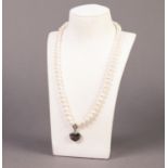 SINGLE STRAND NECKLACE OF FRESHWATER PEARLS with silver clasp and heart shaped pendant front