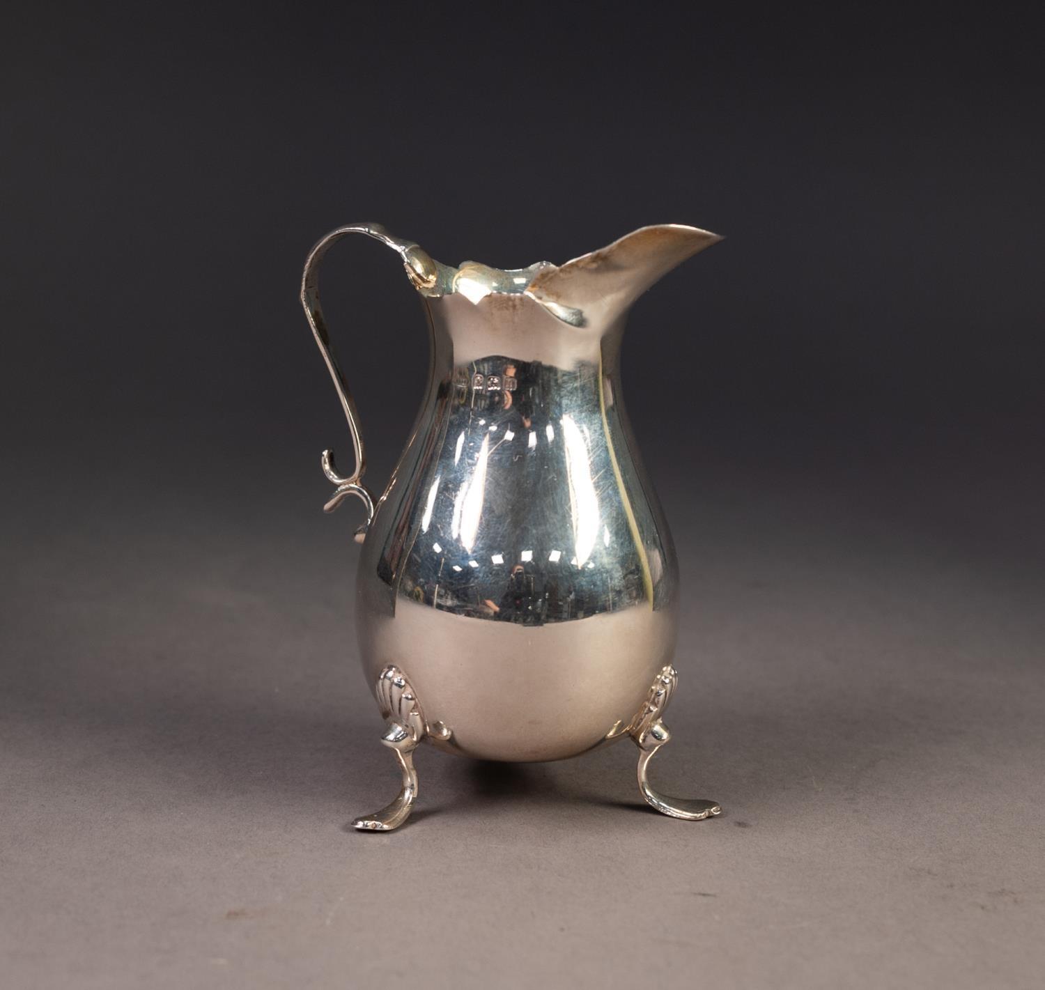 GEORGE V PLAIN SILVER CREAM JUG, of pyriform with shaped rim, scroll handle and shell capped