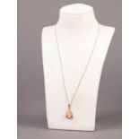 9ct GOLD FINE CHAIN NECKLACE and an unmarked GOLD COLOURED METAL PENDANT set with a small shell