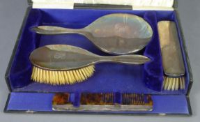 *GEORGE V CASED FOUR PIECE PLAIN SILVER CLAD HAND MIRROR AND BRUSH SET, including a tortoiseshell