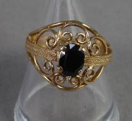 9ct GOLD DRESS RING, the broad circular scrolled wire pattern top set with a dark oval sapphire,