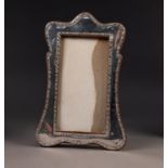 EDWARD VII SILVER FRONTED OAK DESK TOP PHOTOGRAPH FRAME, of wavy outline with arch top and