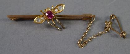 EDWARDIAN 15ct GOLD BAR AND FLY BROOCH, the fly with a ruby body and two tiny rose diamonds to