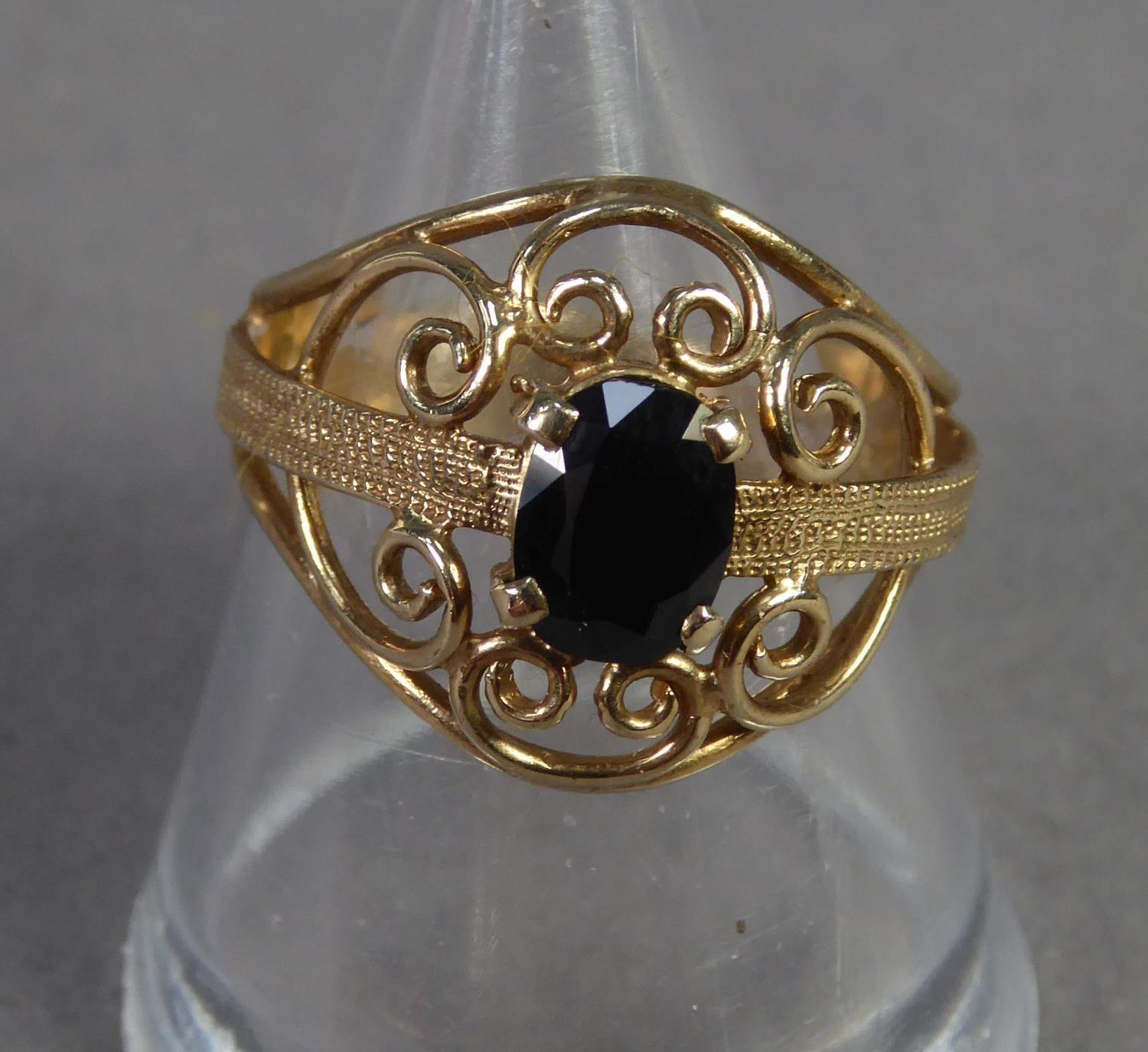 9ct GOLD DRESS RING, the broad circular scrolled wire pattern top set with a dark oval sapphire, - Image 2 of 2