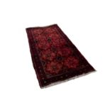 SHIRAZ PERSIAN RUG, with two rows of five stellate medallions, stencilled on the dark crimson