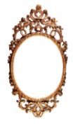 TWENTIETH CENTURY CARVED GILT WOOD WALL MIRROR, the later oval plate housed in a gadroon moulded