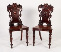 PAIR OF EARLY VICTORIAN CARVED MAHOGANY HALL CHAIRS, each with an ornate back carved with a
