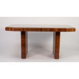 ART DECO FIGURED WALNUT DINING TABLE, the quarter cut, canted oblong top, with glass protector,