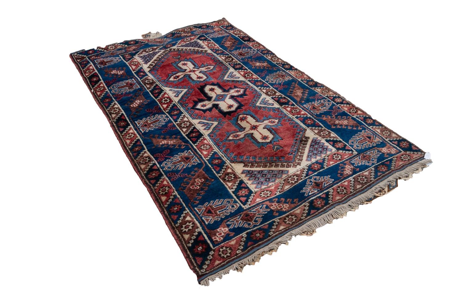 TURKISH RUG, the narrow red field decorated with three cross shaped medallions in off-white and