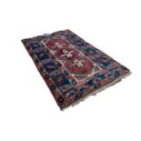 TURKISH RUG, the narrow red field decorated with three cross shaped medallions in off-white and