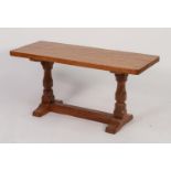 MOUSEMAN THOMPSON OAK COFFEE TABLE, the adzed top with rounded corners standing on polygonally
