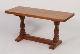 MOUSEMAN THOMPSON OAK COFFEE TABLE, the adzed top with rounded corners standing on polygonally