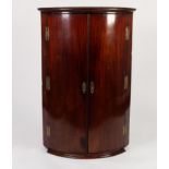 EARLY NINETEENTH CENTURY MAHOGANY BOW FRONTED CORNER CUPBOARD, of typical form with six exposed
