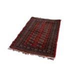 BOKHARA PATTERN EASTERN RUG, with two rows of primary guls on a crimson field, with principal border