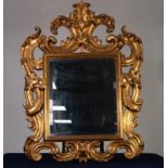 MODERN ROCOCO STYLE CARVED GILTWOOD WALL MIRROR, the bevelled oblong plate within a moulded slip and