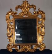 MODERN ROCOCO STYLE CARVED GILTWOOD WALL MIRROR, the bevelled oblong plate within a moulded slip and