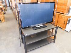 A PANASONIC 42" TV WITH A GLASS THREE TIER STAND