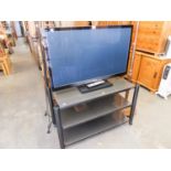 A PANASONIC 42" TV WITH A GLASS THREE TIER STAND