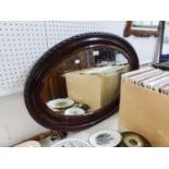 AN OVAL BEVELLED EDGE WALL MIRROR, IN STAINED CAVETTO FRAME