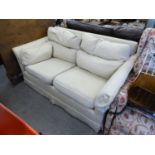 A WESLEY BARREL TWO SEATER SETTEE COVERED IN BEIGE FABRIC