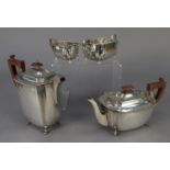 FOUR PIECE ELECTROPLATED TEASET, of rounded oblong form with brown angular scroll handles,