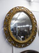 AN OVAL ORNATE GILT FRAMED WALL MIRROR AND A VINTAGE BAGATELLE GAME (2)