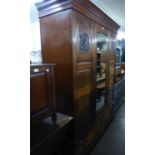 AN EDWARDIAN MAHOGANY INLAID TRIPLE DOOR WARDROBE, WITH CENTRAL MIRROR DOOR, RAISED ON A TWO