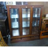 A MAHOGANY DISPLAY CABINET WITH CENTRE GLAZED PANEL, FLANKED BY TWO GLAZED DOORS, ON PLINTH BASE