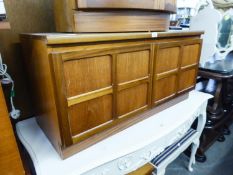 A NATHAN, TEAK LOW SMALL CUPBOARD, ENCLOSED BY TWO FOUR PANEL DOORS